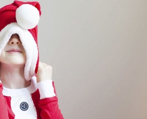 Kind zieht sich Weihnachtsmütze über den Kopf- zu viel gegessen, gehört oder ist ihm alles zu viel?